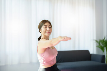 Fototapeta na wymiar stress relief, muscle relaxation, breathing exercises, exercise, meditation, portrait of Young Asian woman relaxing her body from office work by practicing yoga by watching online tutorials.