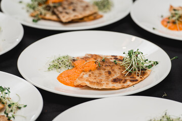 Cheburek traditional balkan meat pastry pie with herbs on a white plate. Served with sauce and micro green