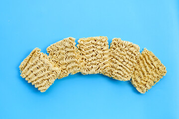 Dried instant noodles on blue background.