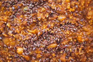 vegan mixed bean soup with couscous and flaxseeds as topping, healthy plant-based food