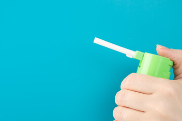 nasal spray for sore throat, from a sore throat in a hand on a blue background