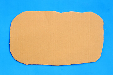 Cut brown cardboard on blue background.