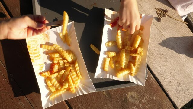 eating fries, dipping in ketchup, outdoor sunny day, close