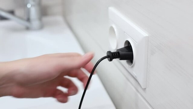 pull the plug from the socket in the bathroom. close-up