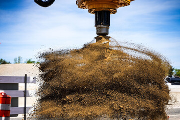 Closeup shot of an excavator with drill attachment spinning off dirt