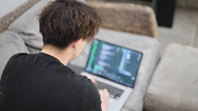 コード画面がイイ感じにぼけたパソコンの仕事をする男性の顔無し　俯瞰　アップ　動画