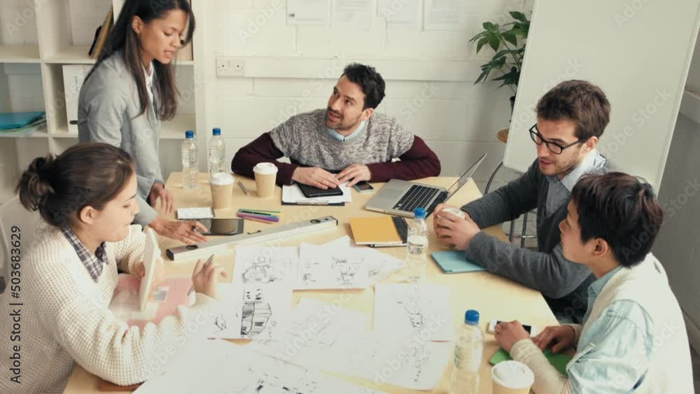 Poster a diverse group of focused businesspeople brainstorming and looking at architectural drawings at the