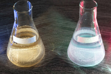 Two glass flasks with different acids (sulphurous, silicic, phosphoric). Place for text inscription chemical. The concept of a preview for a product card on the site.