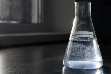 Selective focus of Phosphoric acid 85% solution in glass flask. High quality photo