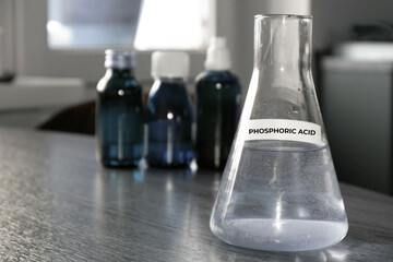 Selective focus of Phosphoric acid solution in glass flask. High quality photo