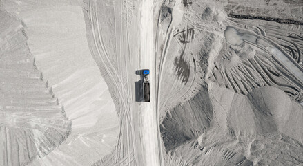 Limestone mining in open quarry, industrial truck with stone, aerial top view banner