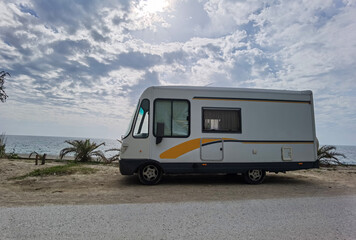 caravan car by the sea in spring season clouds and sun in the sky