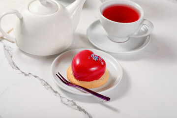 Fresh dessert on a white plate among white dishes with tea and coffee in a cafe