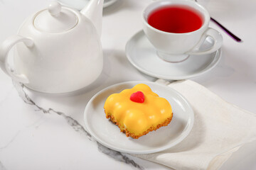 Fresh dessert on a white plate among white dishes with tea and coffee in a cafe