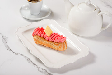 Fresh dessert on a white plate among white dishes with tea and coffee in a cafe