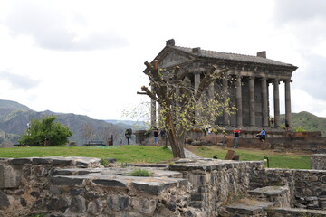 The oldest pagan temple of Garni in Armenia, against the backdrop of the fresh greenery of the mountains on a May day. Travel concept.