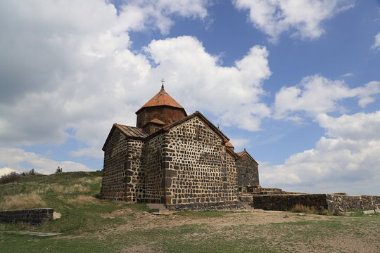 Church of the ancient Sevanavank monastery on Lake Sevan in Armenia - against a blue sky with white clouds.