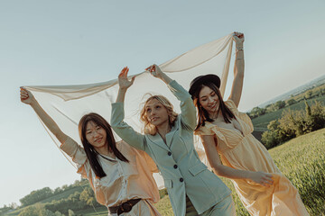 Three happy girls smiling outdoors in the countryside.