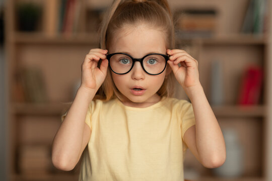 Little Girl Wearing Eyeglasses Having Poor Eyesight Posing At Home