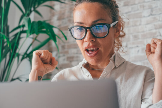 Woman Sit On Sofa Put Pc On Lap Clenched Fists Scream With Joy While Read Great News On Laptop. Gambler Celebrate Online Auction Bet Victory. Got Incredible Offer Sincere Emotions Of Happiness 