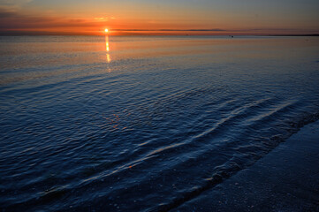 Sole al tramonto sul Mare con acqua calma e con poche onde - 503689462