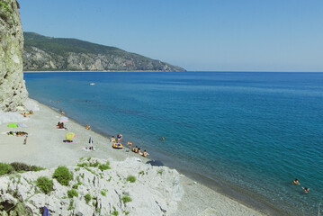 View of blue water and rocky mountains under a sunny sky in Spiaggia Marinella in Centola, Italy