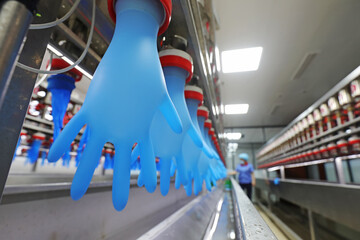 female workers inspect the quality of nitrile gloves in a water test at a processing plant in North China