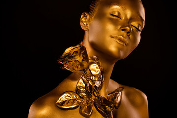 Hot gorgeous lady covered by golden glitter shimmer close her eyes try magical rose flower touch on...