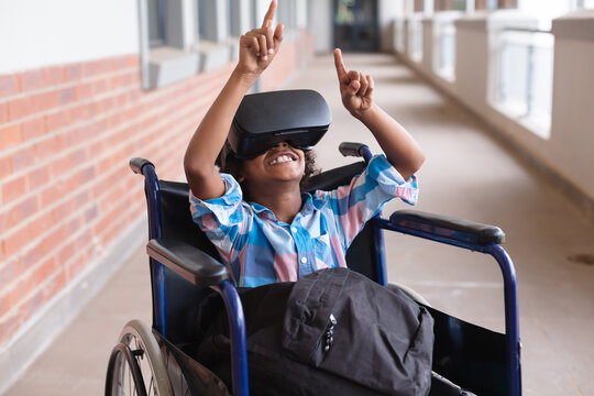 Cheerful disabled african american elementary schoolboy gesturing while wearing vr glasses