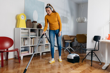 woman vacuuming floor at home