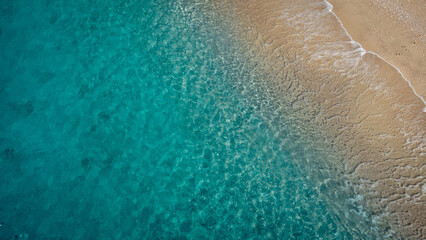 Aerial view of beautiful sandy beach and soft turquoise ocean wave. Tropical sea in summer season on Egremni beach on Lefkada island.