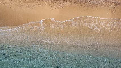 Aerial view of beautiful sandy beach and soft turquoise ocean wave. Tropical sea in summer season on Egremni beach on Lefkada island.