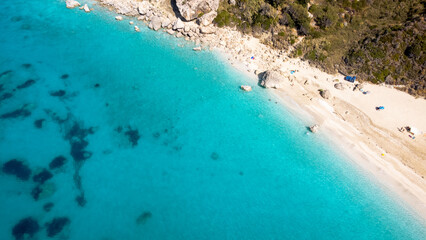 Aerial view of beautiful sandy beach with sunshades and soft turquoise ocean wave. Tropical sea in...