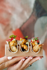 Girl holding shrimps tacos in hand food lifestyle photo
