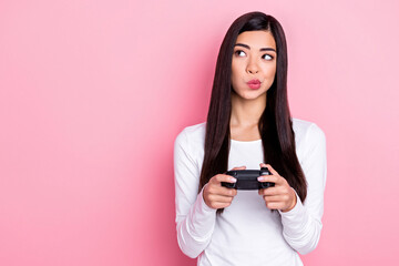 Photo of unsure millennial brunette lady playstation look empty space wear white shirt isolated on pink color background