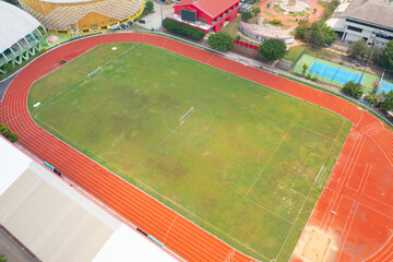 Obraz premium Aerial top view of rubber floor, red running track on a sports stadium with grandstand. Sport and recreation background.