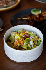Vegetable salad with prawns served in white bowl
