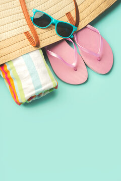 Summer holiday concept.Top view of beach bag with flip flops,beach towel,sunglasses and space for text