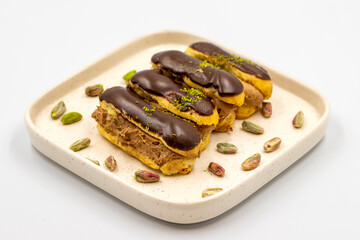 Chocolate eclair cake. Pistachio and chocolate eclair cake on a white background. close up