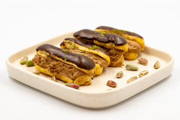 Chocolate eclair cake. Pistachio and chocolate eclair cake on a white background. close up
