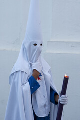 Vertical shot of a person with a white traditional capirote for the Spanish Holy Week processions