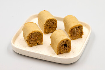 Roll cake with hazelnut and chocolate filling. roll cake on a white background. close up