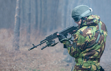 military man aiming with a rifle in the forest