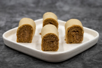 Roll cake with hazelnut and chocolate filling. roll cake on a dark background. close up