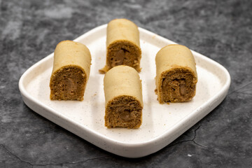 Roll cake with hazelnut and chocolate filling. roll cake on a dark background. close up