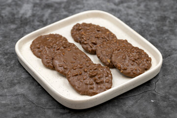 Special chocolate with hazelnut particles. Chocolate with hazelnuts on a dark background. close up