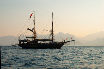 Fototapeta na wymiar tourist sailing ship at sea at dawn