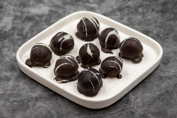 Special chocolate with dark outside and coconut inside. Dark chocolate with coconut filling on a dark background. close up