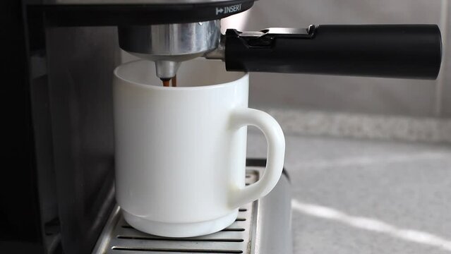 a cup of coffee in a coffee machine close-up