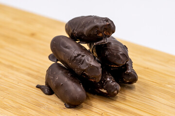 Special chocolate with dark outside and coconut inside. Dark chocolate with coconut filling on a wooden background. close up